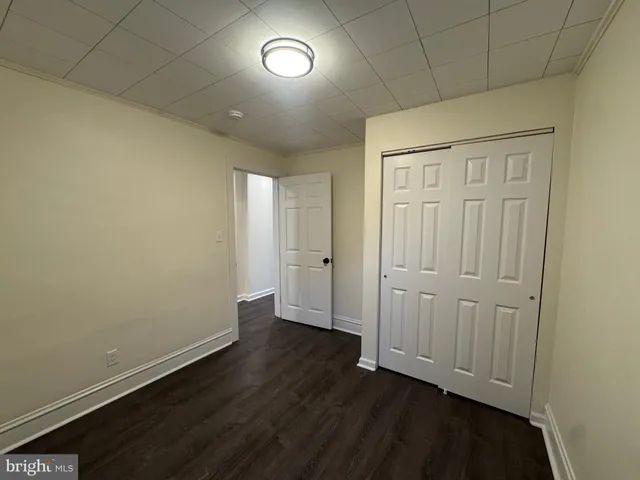 an empty room with wooden floor and closet