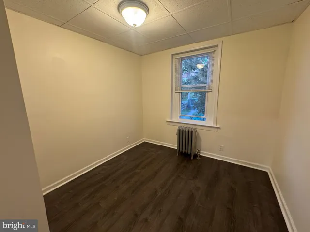 an empty room with wooden floor and a window