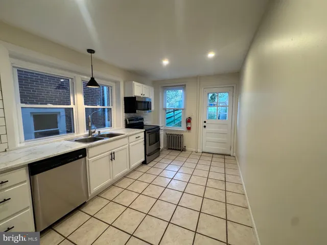 a kitchen with stainless steel appliances a sink stove and cabinets