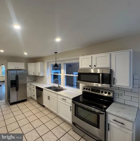 a kitchen with stainless steel appliances a stove a sink and a refrigerator