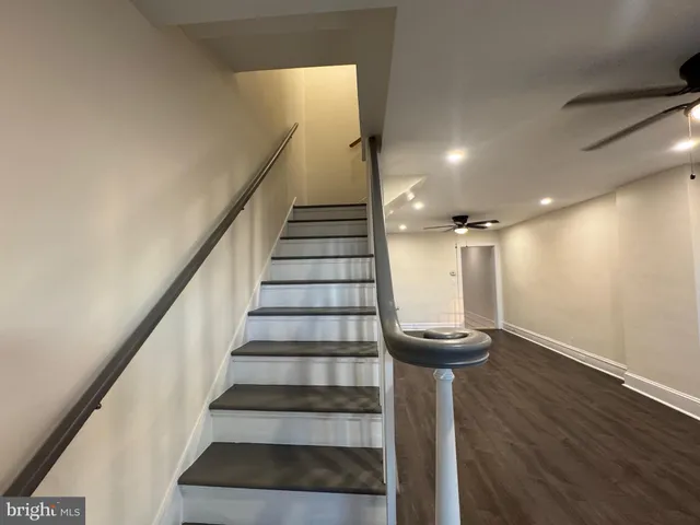 a view of a hallway with wooden floor and a chandelier