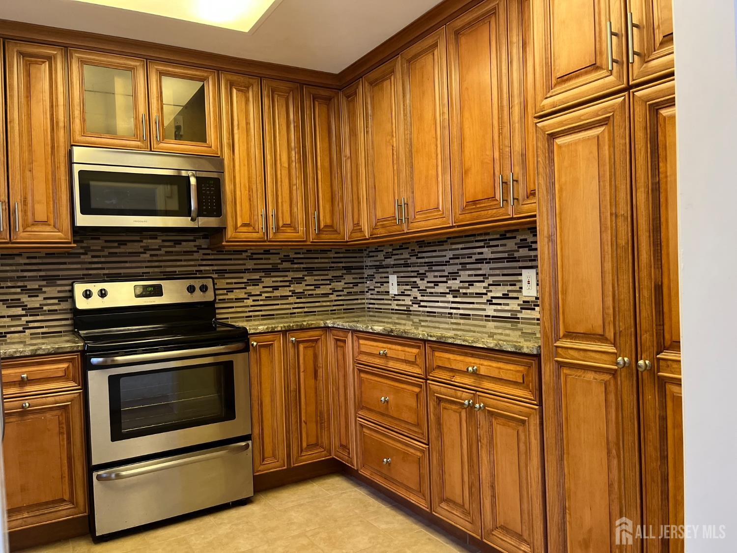 333 Newport Way, Unit C Monroe Township, NJ 08831 - Photo 14 of 17 a kitchen with granite countertop cabinets stainless steel appliances and a window