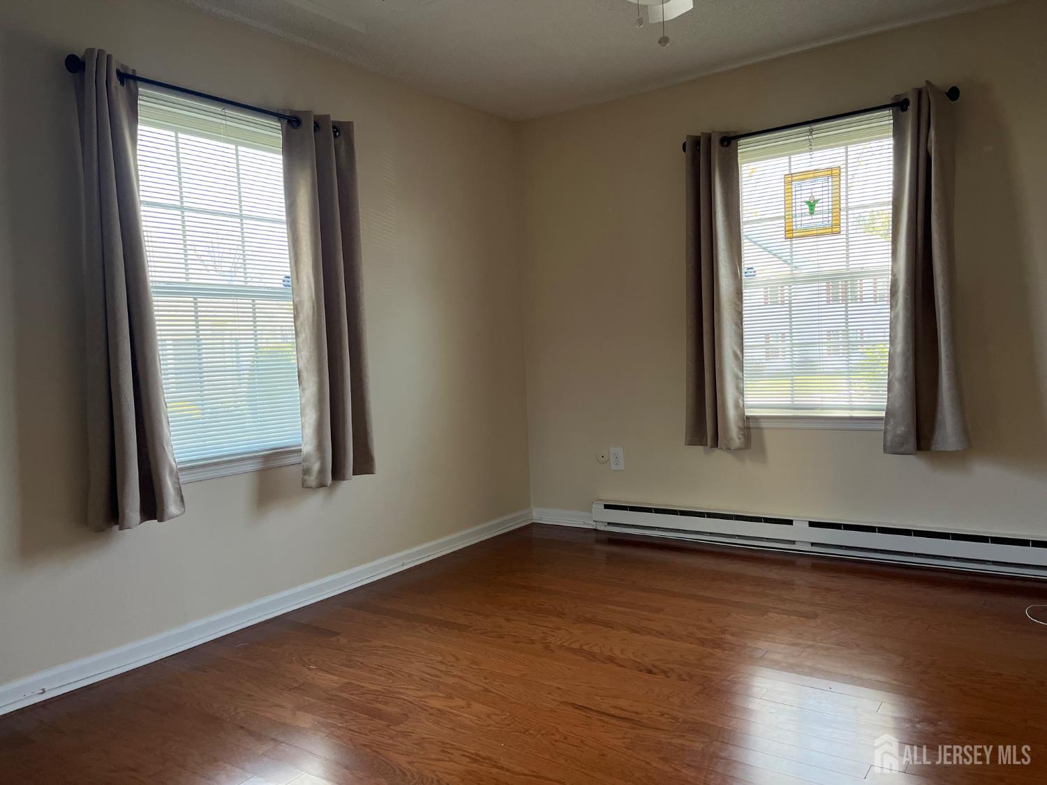 333 Newport Way, Unit C Monroe Township, NJ 08831 - Photo 6 of 17 a view of an empty room with wooden floor and a window