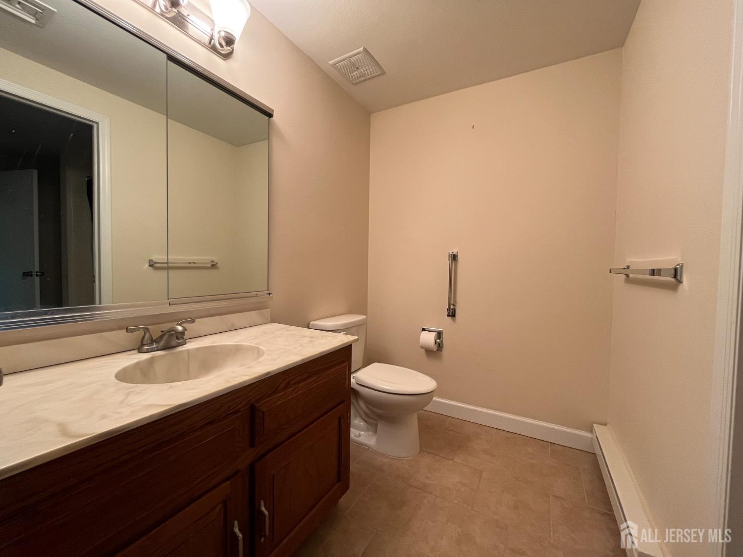 333 Newport Way, Unit C Monroe Township, NJ 08831 - Photo 8 of 17 a bathroom with a sink a toilet and mirror