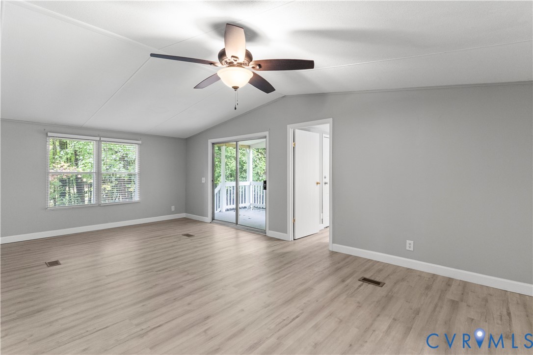 403 Virso Road Meherrin, VA 23954 - Photo 18 of 33 an empty room with wooden floor chandelier fan and windows
