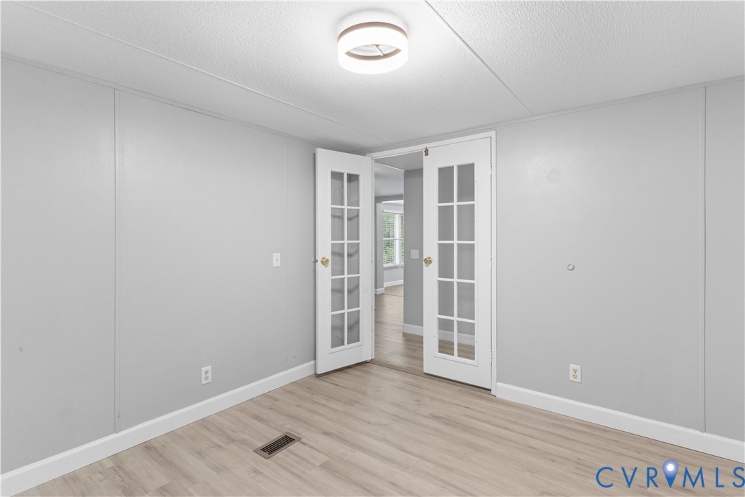 403 Virso Road Meherrin, VA 23954 - Photo 20 of 33 an empty room with wooden floor and windows