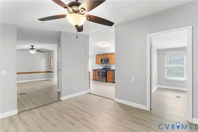 an empty room with wooden floor and ceiling fan