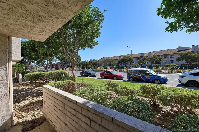 a view of a garden with cars park