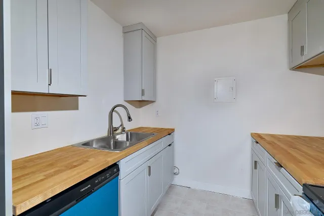 a kitchen with granite countertop white cabinets and a sink