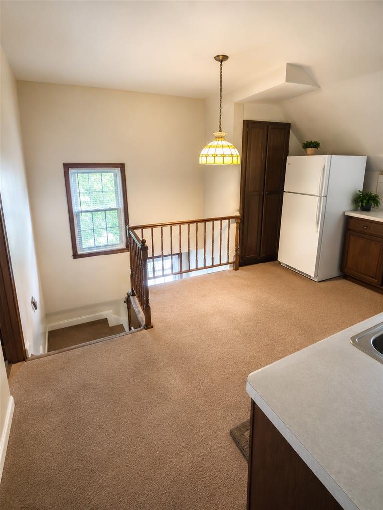 2836 Nazareth Road Easton, PA 18045 - Photo 12 of 19 An inviting open-concept living space features warm carpeting and a bright window overlooking a staircase with a classic wooden railing.