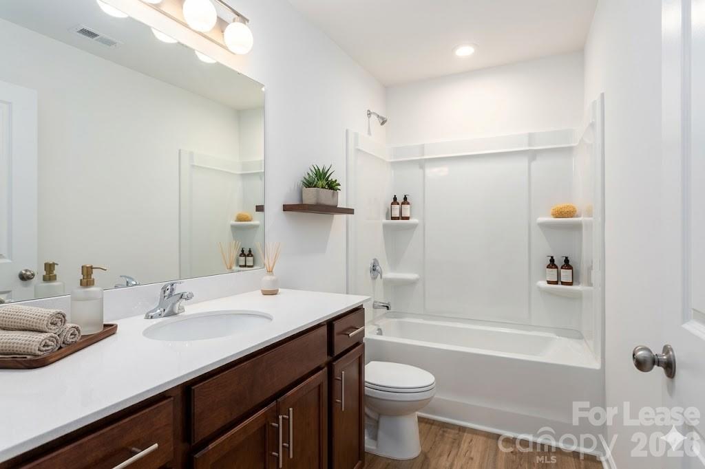 1215 Nesters Store Place Southwest Concord, NC 28027 - Photo 11 of 16 a bathroom with a bathtub shower sink vanity mirror and toilet