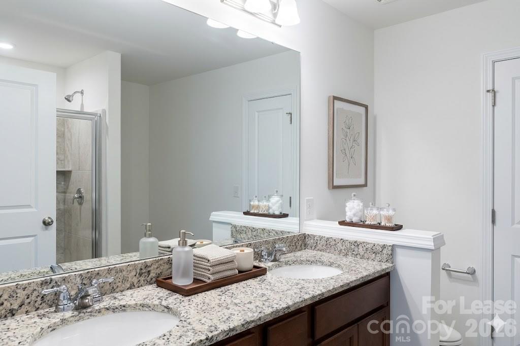 1215 Nesters Store Place Southwest Concord, NC 28027 - Photo 14 of 16 a bathroom with double vanity sinks and a mirror