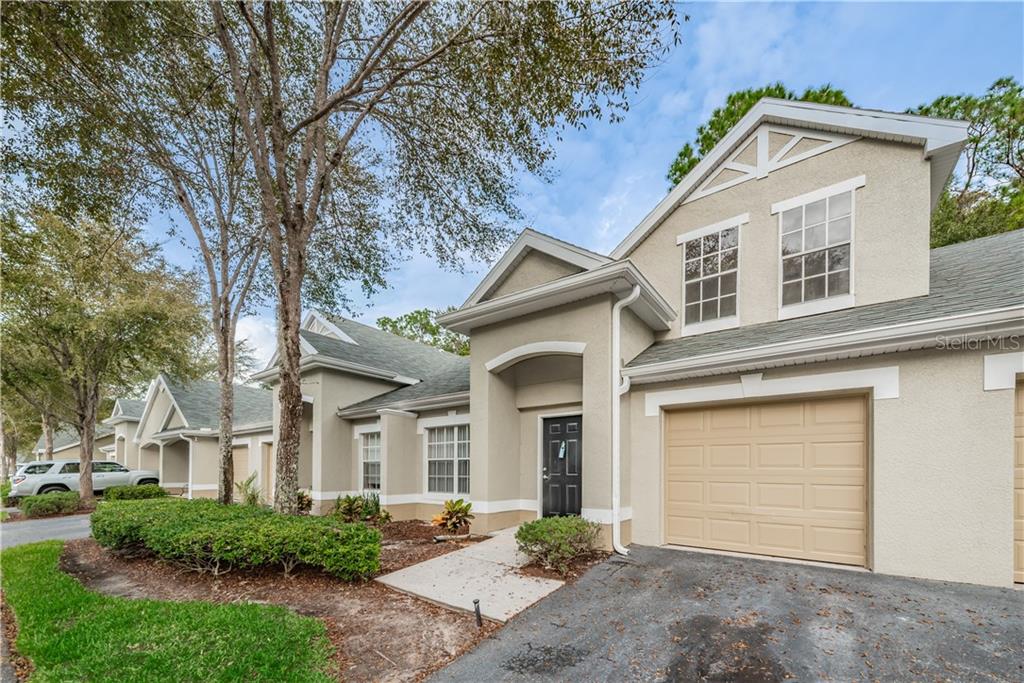 3549 Kings Road, Unit 104 Palm Harbor, FL 34685 - Photo 1 of 1 a front view of a house with a yard and garage