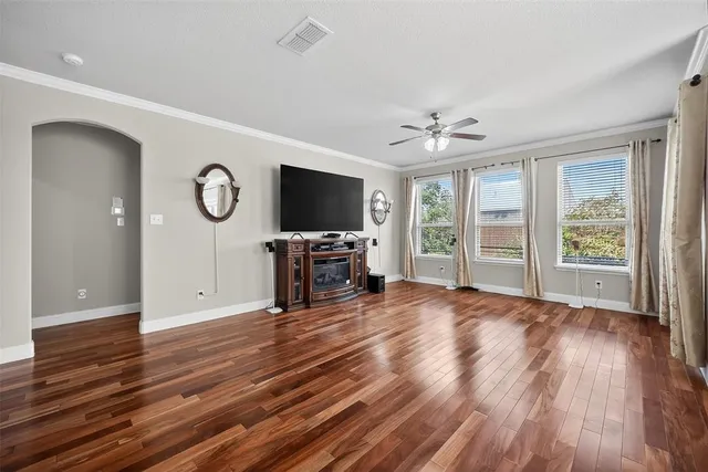 a view of an empty room with a window and wooden floor
