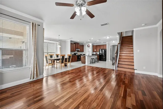a view of large livingroom with wooden floor and staircase