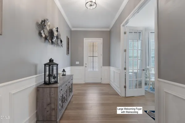 a hallway with a large cabinets and chandelier