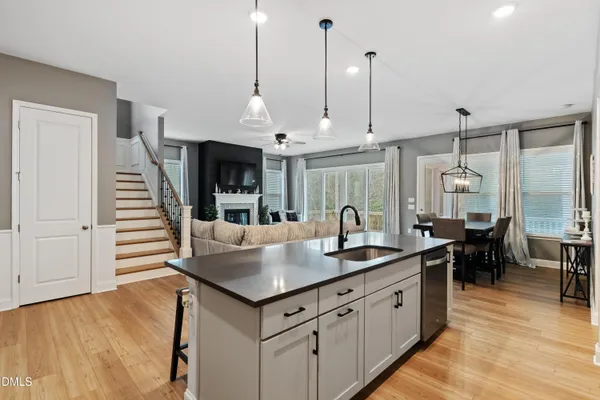 a modern kitchen with stainless steel appliances granite countertop a sink and a refrigerator
