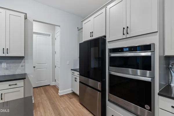 a kitchen with stainless steel appliances granite countertop a sink a stove and a wooden floors