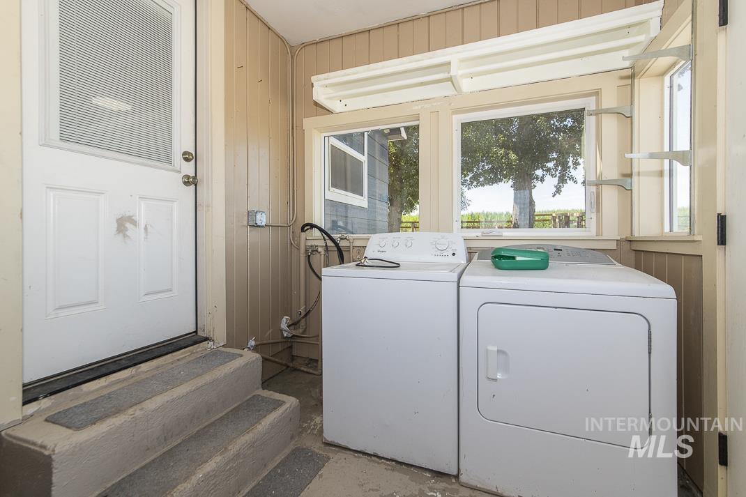 3432 West Pioneer Road Homedale, ID 83628 - Photo 12 of 21 Washroom with wooden walls and washing machine and clothes dryer