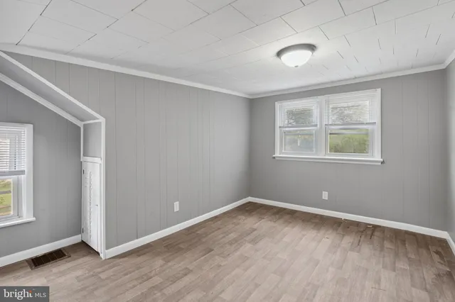 an empty room with windows and closet