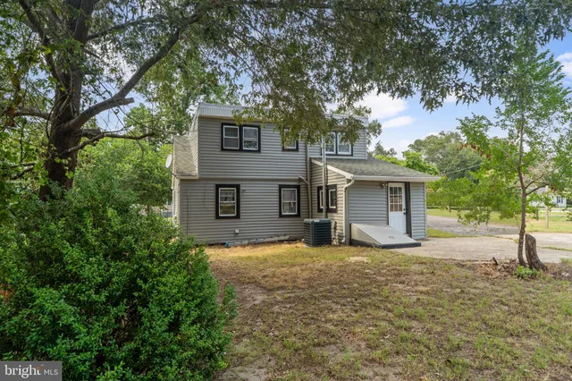 a view of a house with a tree in front of it