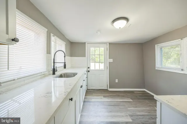a kitchen with granite countertop cabinets stainless steel appliances and wooden floor