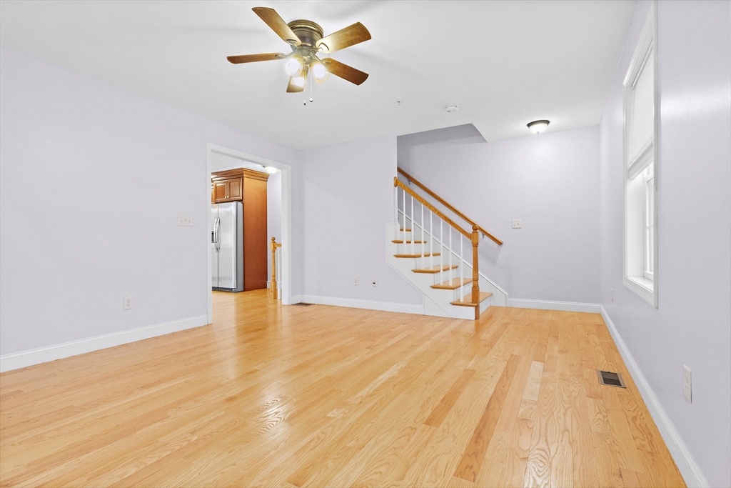 7 Butler Avenue, Unit 5 Lowell, MA 01852 - Photo 7 of 28 a view of an empty room with wooden floor and a ceiling fan
