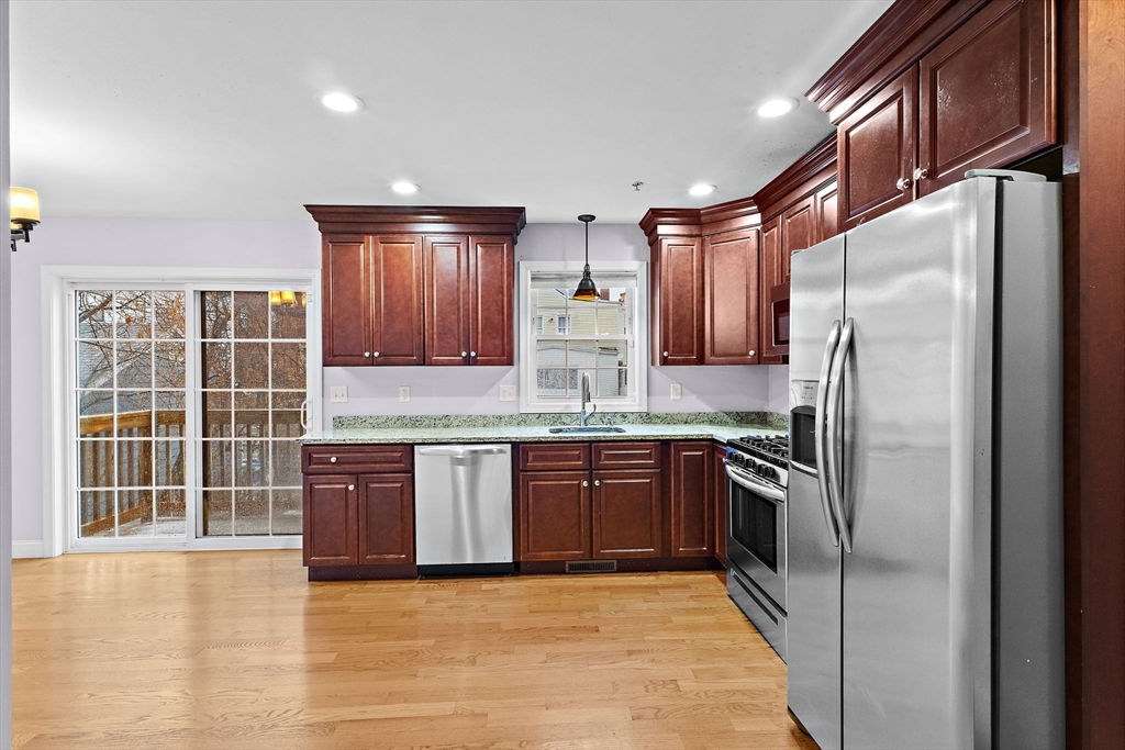 7 Butler Avenue, Unit 5 Lowell, MA 01852 - Photo 9 of 28 a kitchen with granite countertop stainless steel appliances and wooden cabinets