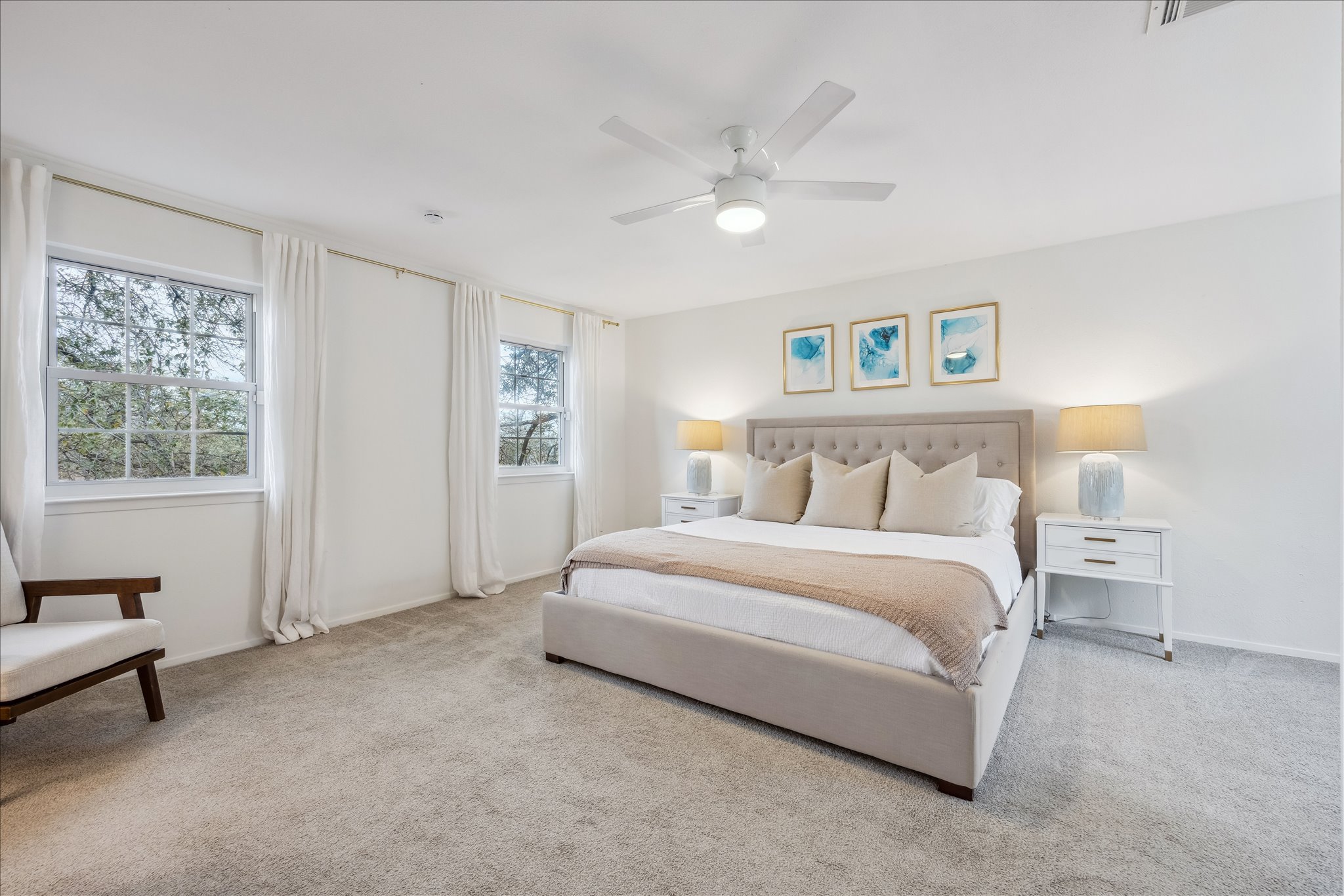 12935 Pegasus Street Austin, TX 78727 - Photo 21 of 38 Enjoy an oversized primary suite with windows on both the front and rear of the home, offering beautiful natural light and a serene, treehouse like atmosphere.