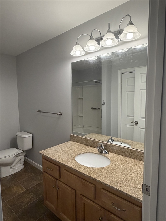 353 Fuller Street, Unit 6 Ludlow, MA 01056 - Photo 19 of 30 a bathroom with a granite countertop sink a toilet and a mirror