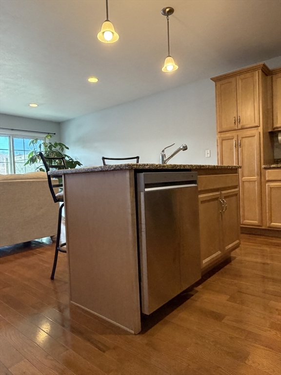 353 Fuller Street, Unit 6 Ludlow, MA 01056 - Photo 7 of 30 a kitchen with stainless steel appliances granite countertop a refrigerator a sink dishwasher a stove and a dining table with wooden floor