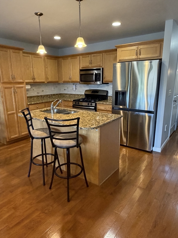 353 Fuller Street, Unit 6 Ludlow, MA 01056 - Photo 10 of 30 a kitchen with kitchen island a refrigerator a stove a microwave oven with a dining table and chairs