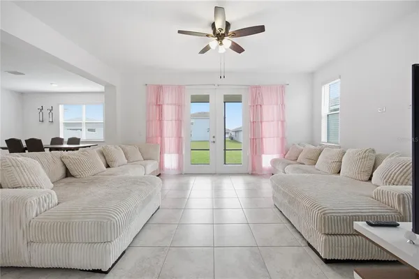 a living room with furniture and a large window with wooden floor