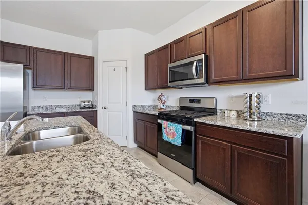 a kitchen with stainless steel appliances granite countertop a sink stove and microwave