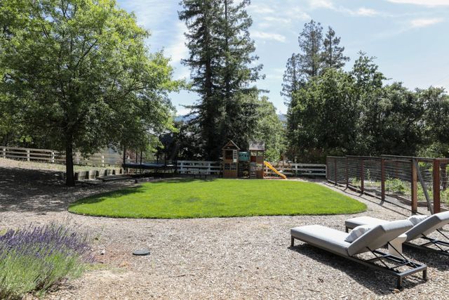 a view of a house with a big yard and large trees