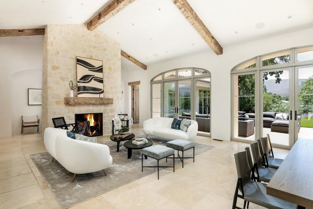 a living room with furniture fireplace and large windows