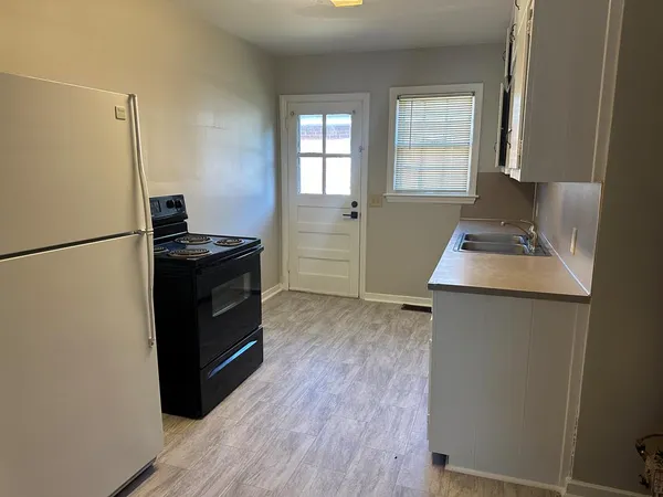 a kitchen with a refrigerator and a stove top oven