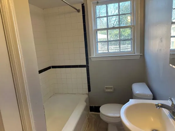 a white toilet sitting next to a window