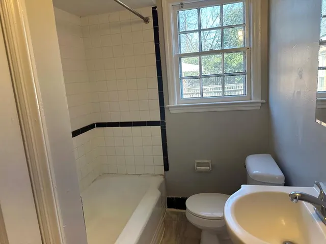 a white toilet sitting next to a window