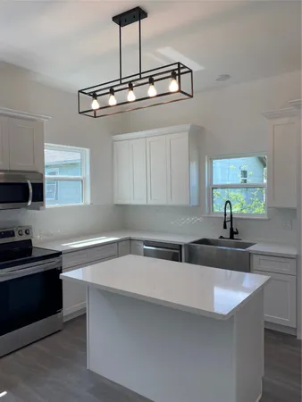 a kitchen with stainless steel appliances a sink a stove and cabinets