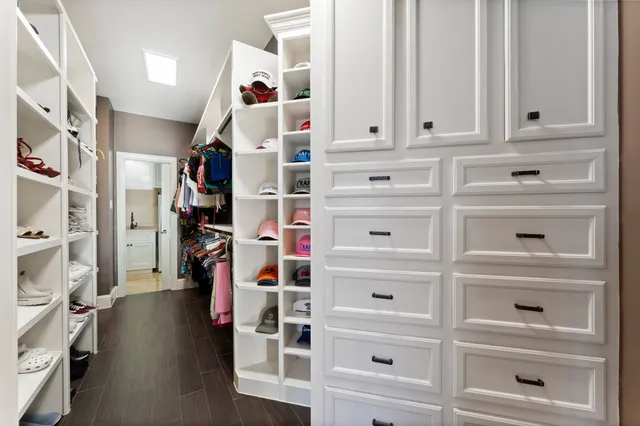 a view of walk in closet with clothes and shoes