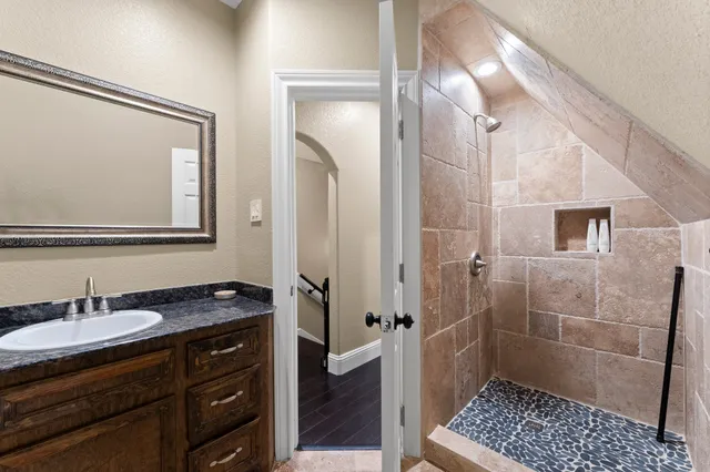 a bathroom with a sink a mirror and a shower