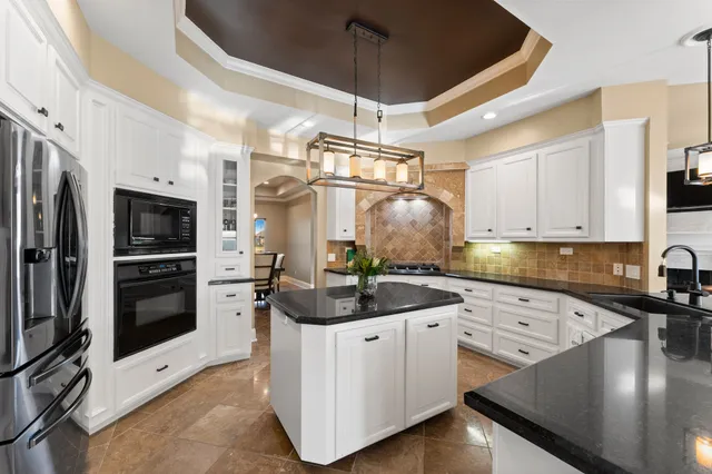 a kitchen with stainless steel appliances a sink a stove a refrigerator cabinets and a counter top space