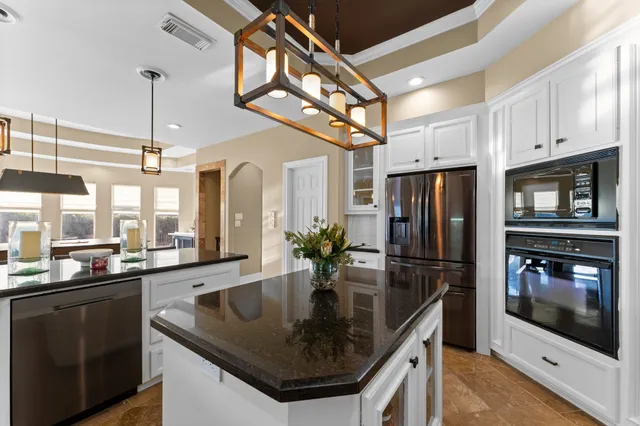 a kitchen with stainless steel appliances granite countertop a sink a microwave and refrigerator