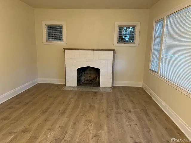 a view of an empty room with a fireplace and a window