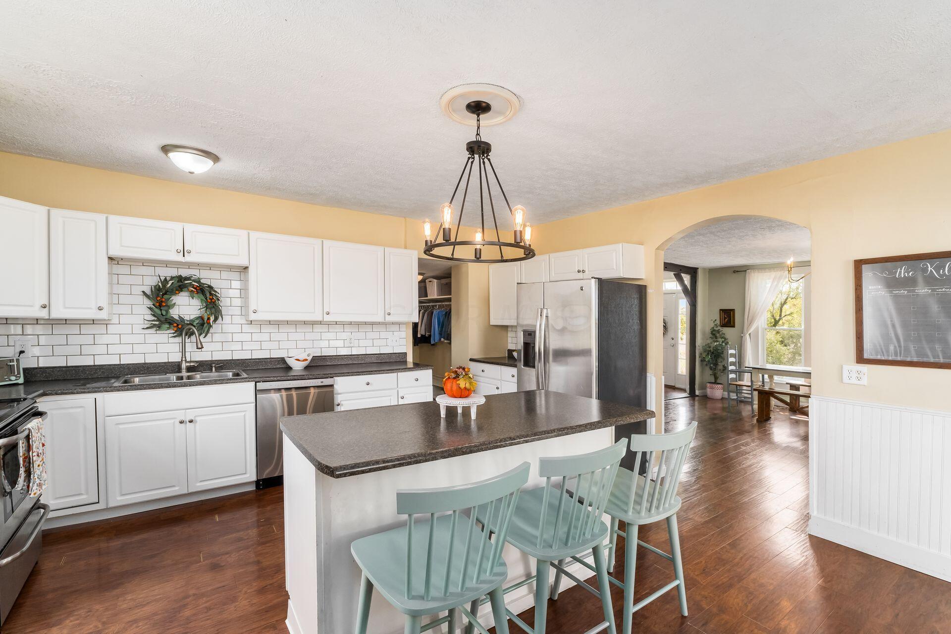 10240 Valentine Road Southwest Stoutsville, OH 43154 - Photo 13 of 60 Dining room into kitchen. Kitchen features loads of prep and cabinet space, stainless appliances and island with seating. Room measures 17'3" x 15'11"