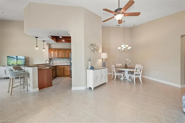 a living room with furniture a dining table and a chandelier