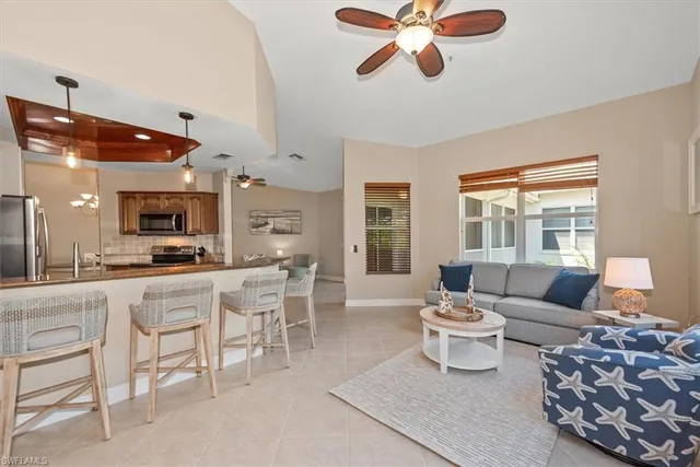 a living room with furniture a flat screen tv and a large window