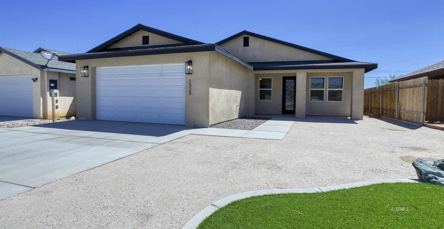 1528 Mayo Street Ridgecrest, CA 93555 - Photo 3 of 34 a front view of a house with a yard and garage