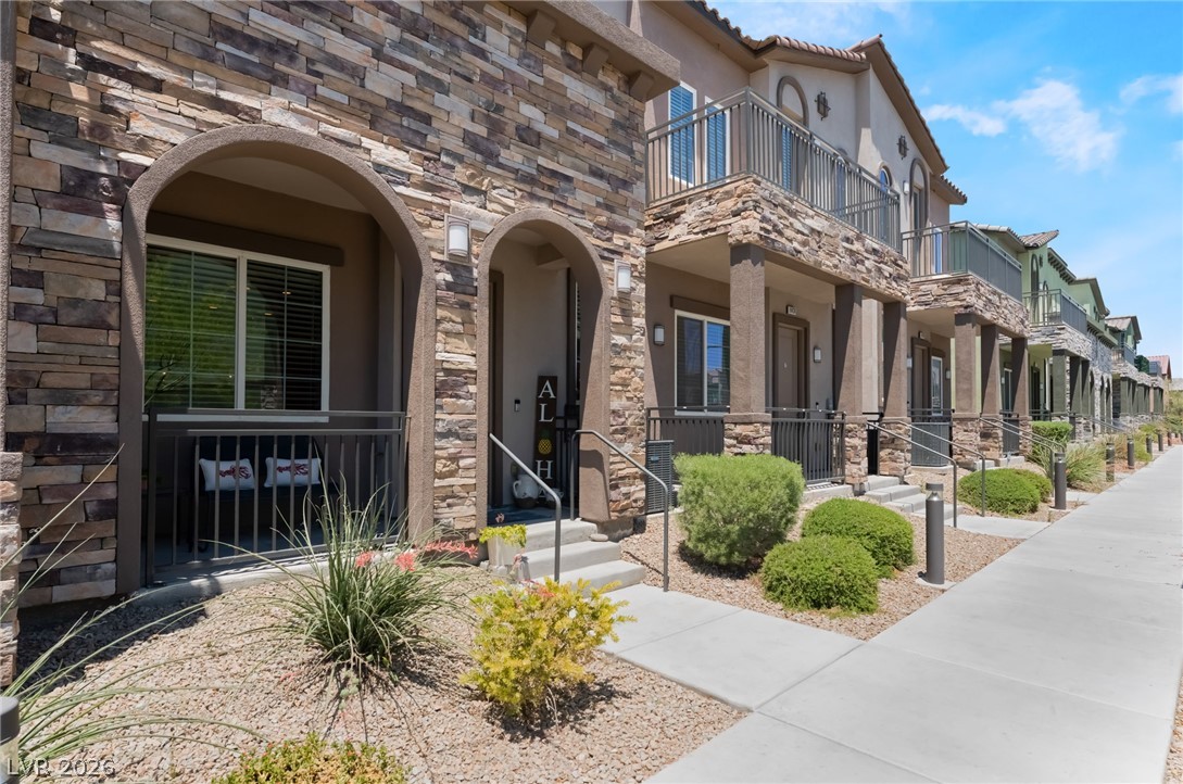 6432 Spring Jog Street Las Vegas, NV 89166 - Photo 3 of 61 Stone veneer accents highlight these inviting townhome entrances with private ground-level patios and upper-level balconies.